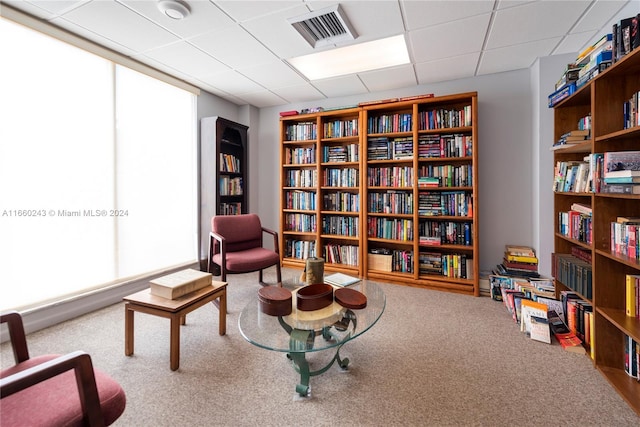 sitting room with carpet floors and a paneled ceiling