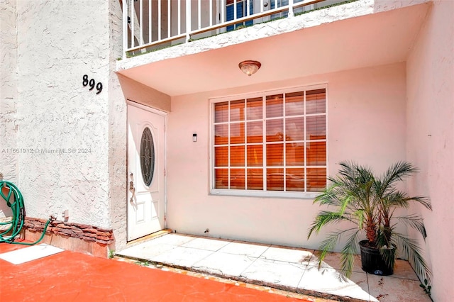 view of exterior entry with a balcony