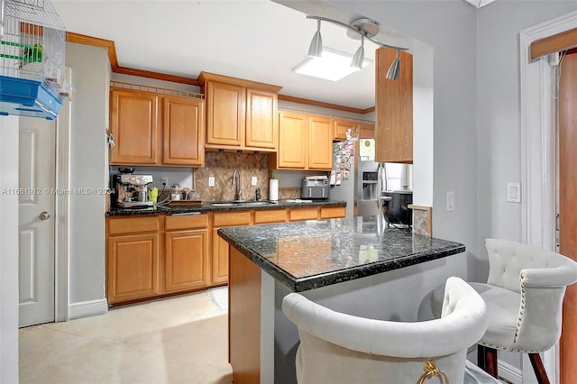 kitchen featuring a kitchen breakfast bar, backsplash, ornamental molding, and sink