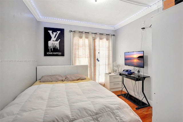 bedroom with light hardwood / wood-style flooring and ornamental molding