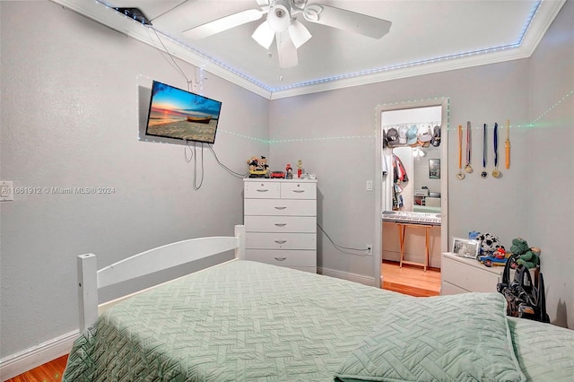 bedroom with ceiling fan, light wood-type flooring, and crown molding