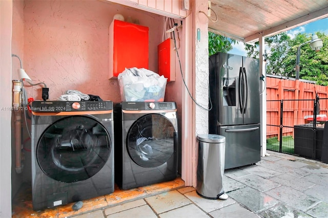 laundry area with washing machine and clothes dryer and wood ceiling