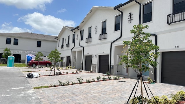 view of front of home with driveway, an attached garage, and stucco siding