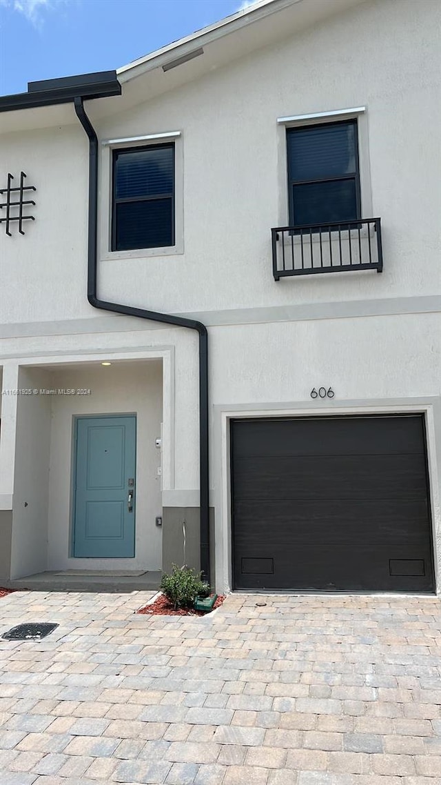 view of front of home featuring stucco siding, an attached garage, and decorative driveway