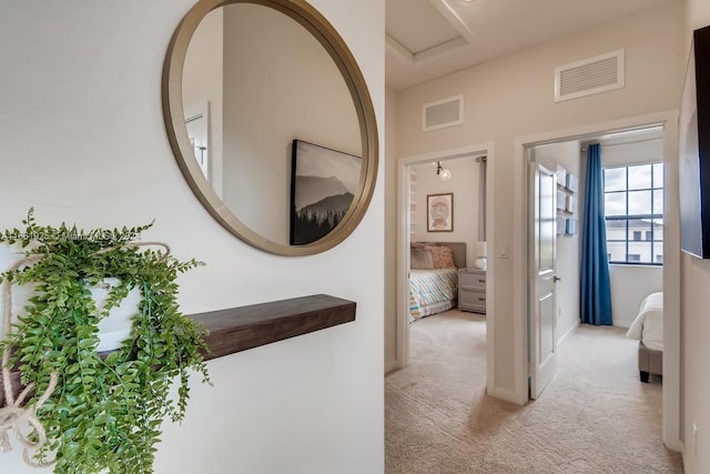 hallway featuring carpet flooring and visible vents