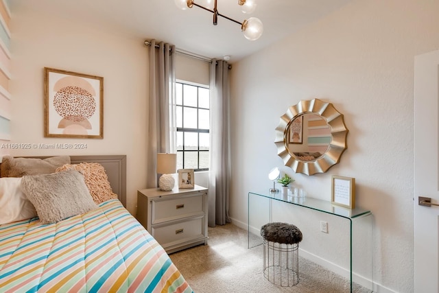 bedroom with light carpet, baseboards, and an inviting chandelier