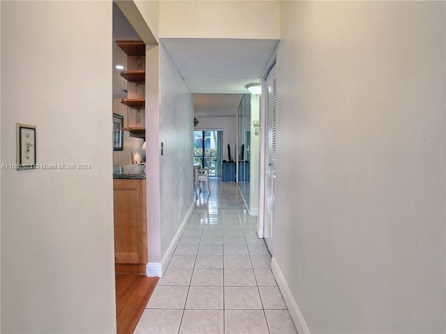 hall featuring light tile patterned floors