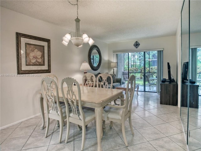 tiled dining area with an inviting chandelier and a textured ceiling