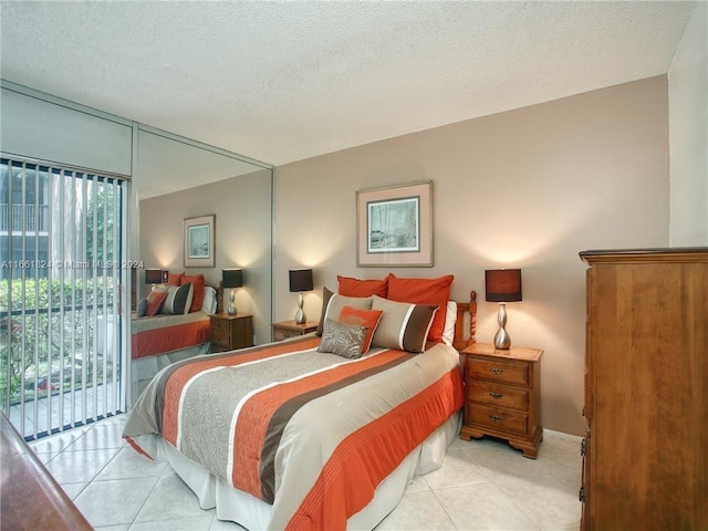 bedroom featuring a textured ceiling, light tile patterned floors, and access to exterior