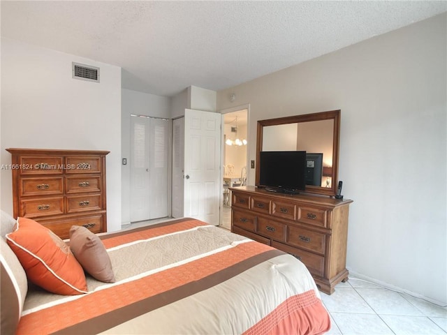 tiled bedroom featuring a closet and a textured ceiling