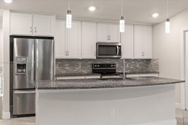 kitchen featuring appliances with stainless steel finishes, a center island with sink, light tile patterned floors, and white cabinets