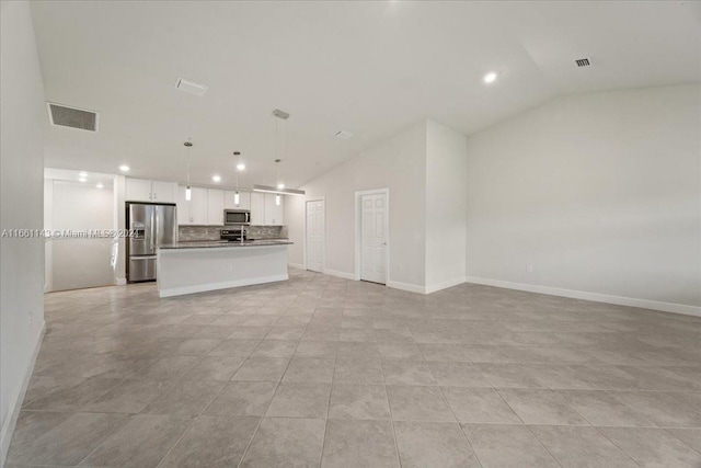 unfurnished living room featuring lofted ceiling and light tile patterned flooring