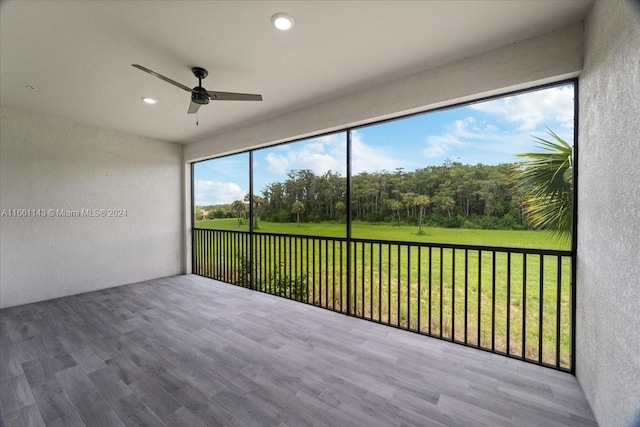 unfurnished sunroom featuring ceiling fan