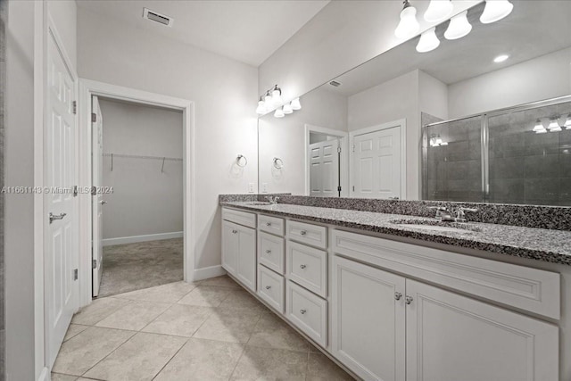 bathroom featuring walk in shower, vanity, and tile patterned flooring