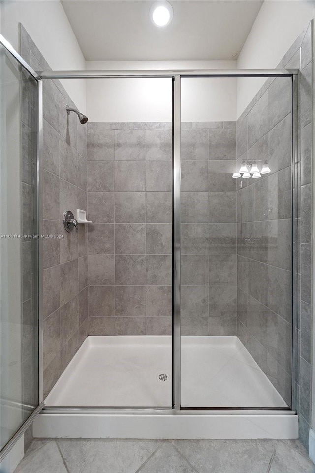 bathroom featuring tile patterned flooring and a shower with shower door