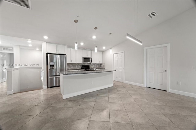 kitchen with white cabinets, an island with sink, light tile patterned floors, decorative light fixtures, and stainless steel appliances