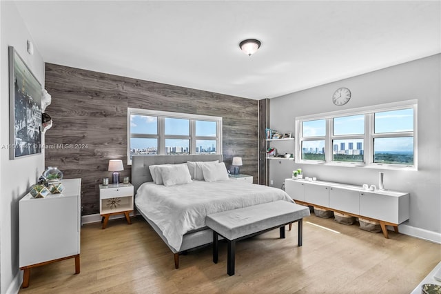 bedroom with wood-type flooring and wooden walls