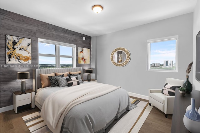 bedroom with wooden walls and dark hardwood / wood-style flooring