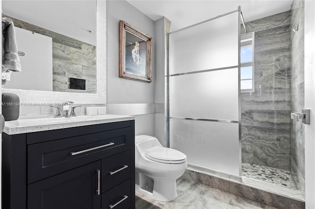 bathroom with tile walls, vanity, toilet, and a shower with door