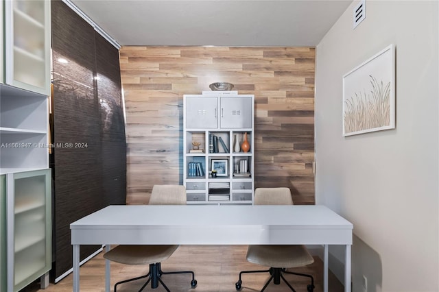 office with wooden walls and hardwood / wood-style flooring