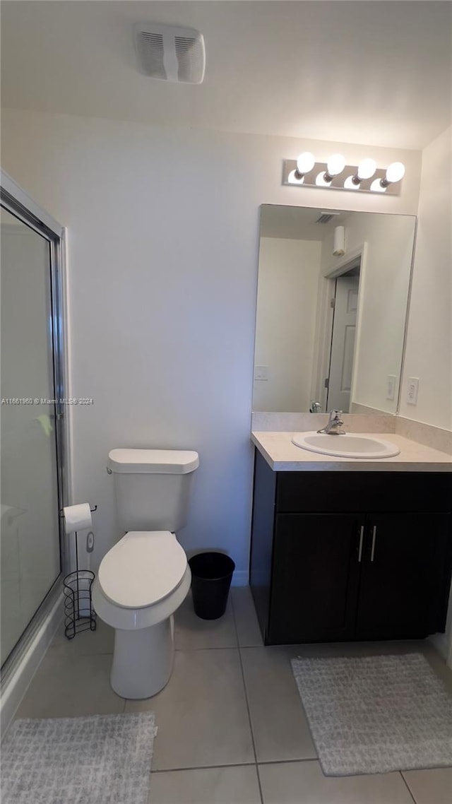 bathroom with vanity, tile patterned floors, toilet, and walk in shower