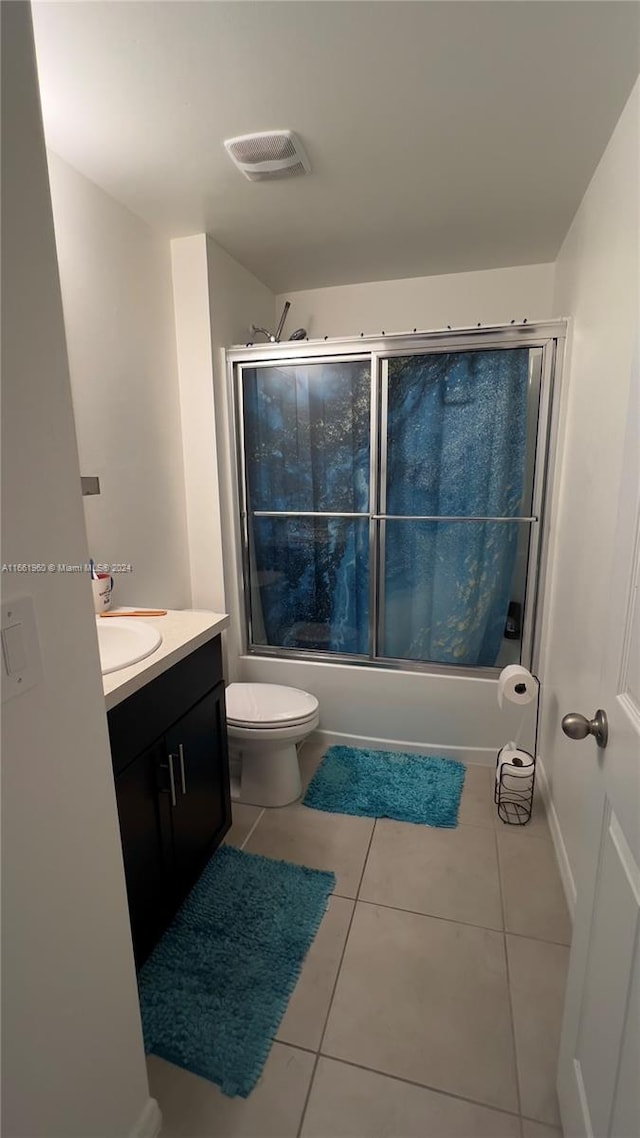 full bathroom with vanity, toilet, combined bath / shower with glass door, and tile patterned flooring