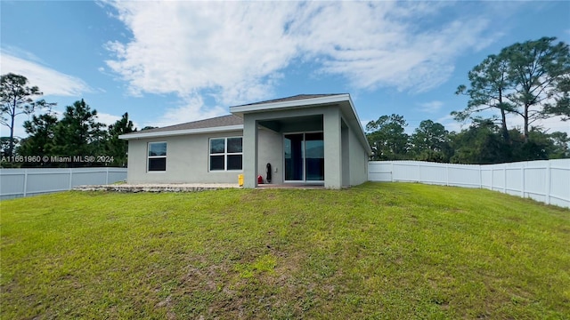 rear view of property featuring a yard