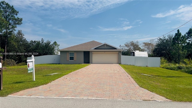 view of front of property with a garage and a front lawn