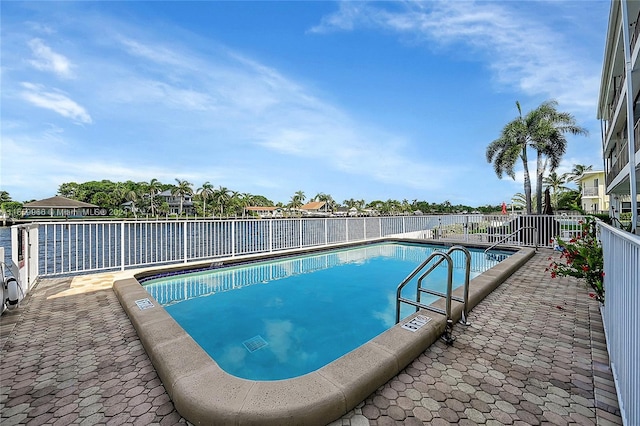 view of pool featuring a patio and a water view