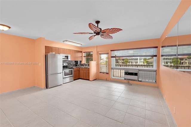 kitchen with ceiling fan, stainless steel appliances, light tile patterned floors, and tasteful backsplash