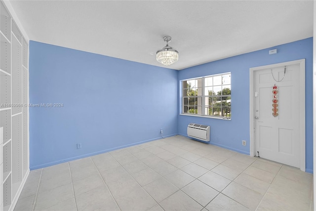 entryway featuring a notable chandelier, an AC wall unit, a textured ceiling, and light tile patterned floors