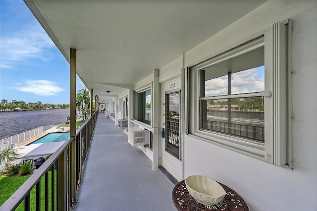 balcony featuring cooling unit and a water view