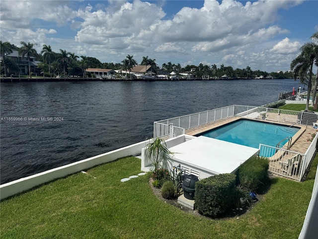 view of pool with a water view, a patio area, and a yard