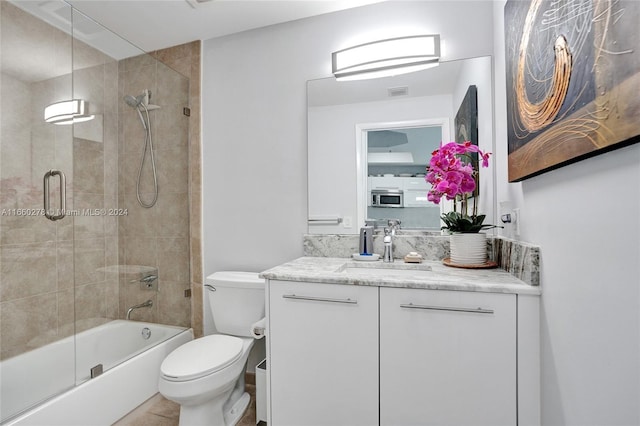 full bathroom featuring vanity, toilet, and bath / shower combo with glass door