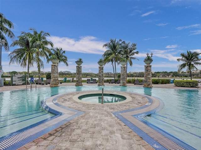 view of swimming pool with a community hot tub and a patio area