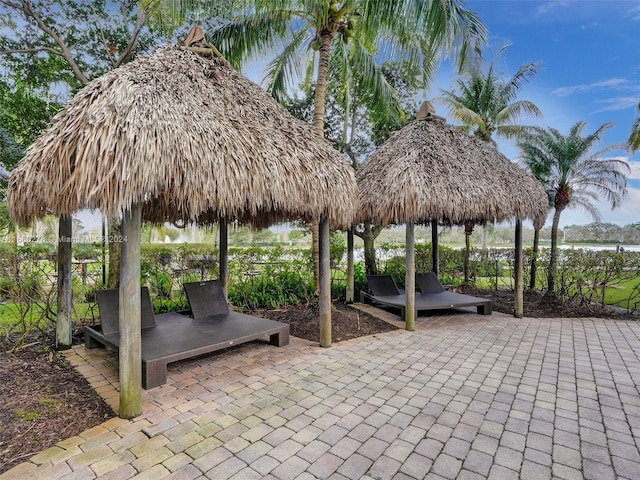 view of property's community featuring a gazebo, a patio area, and a water view