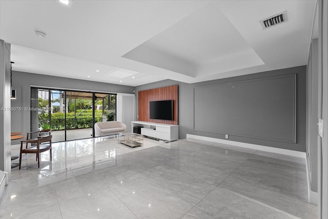 unfurnished living room featuring a tray ceiling