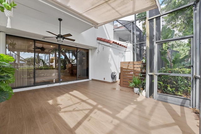 unfurnished sunroom with ceiling fan