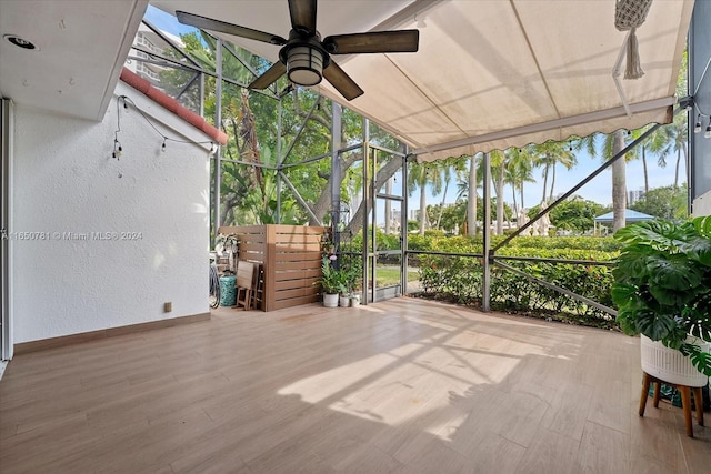 unfurnished sunroom featuring ceiling fan and a healthy amount of sunlight