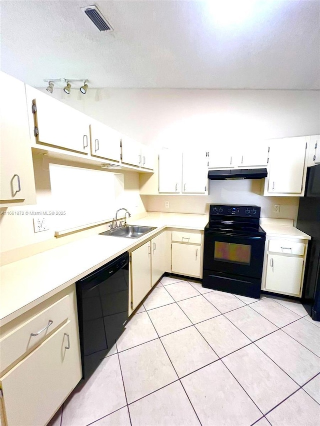 kitchen with black appliances, light tile patterned flooring, white cabinetry, and sink