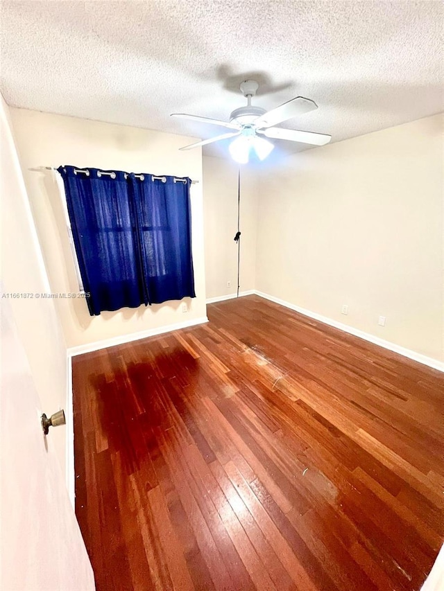 spare room with a textured ceiling, hardwood / wood-style flooring, and ceiling fan