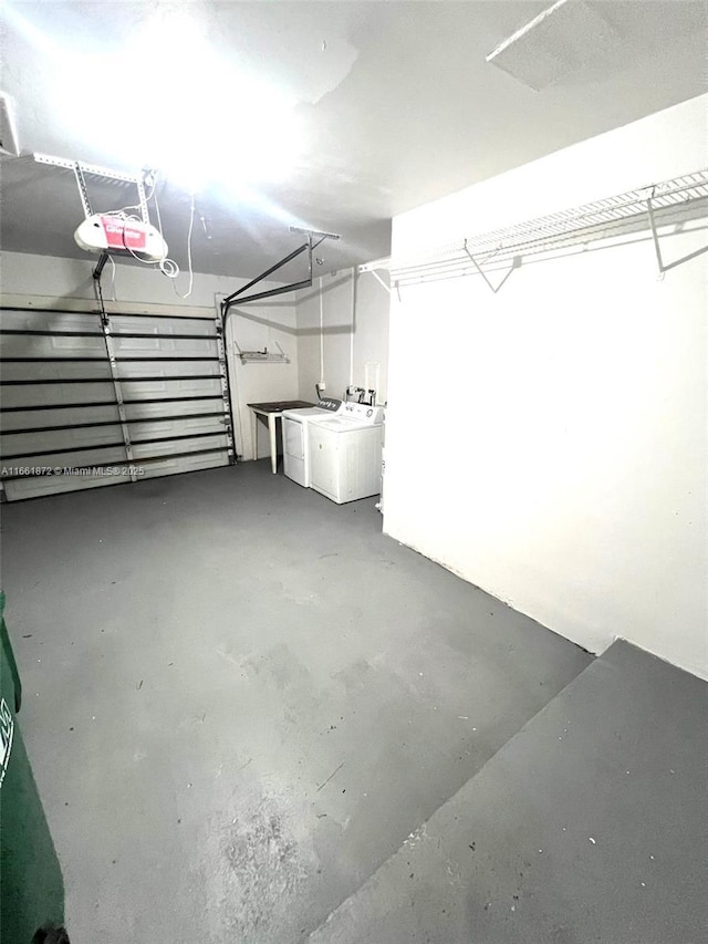 garage featuring independent washer and dryer and a garage door opener