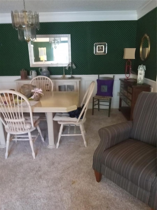 dining area featuring ornamental molding, sink, carpet floors, and a notable chandelier