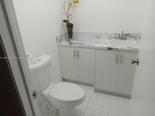 bathroom with tile patterned flooring, vanity, and toilet