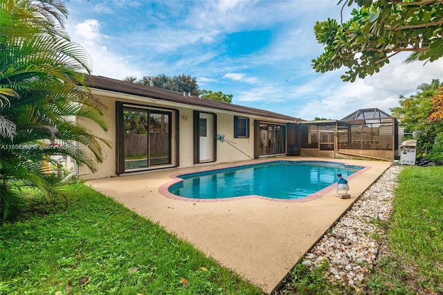 view of swimming pool with glass enclosure and a patio area