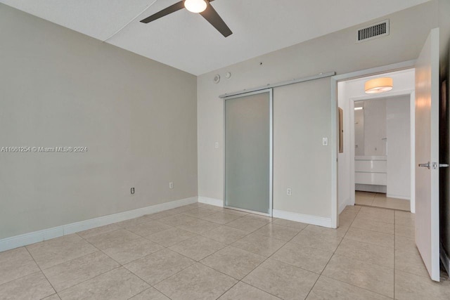 unfurnished bedroom with light tile patterned floors, ceiling fan, and a closet