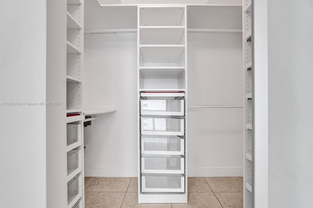 walk in closet with light tile patterned floors