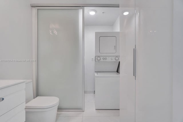 bathroom with vanity, toilet, tile patterned flooring, and stacked washer and dryer