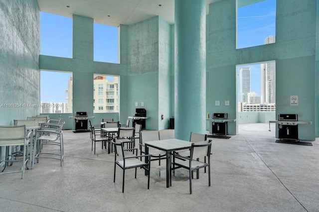 dining area with concrete flooring and a towering ceiling