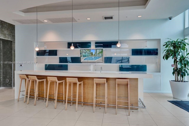 kitchen with pendant lighting, a breakfast bar area, and light tile patterned flooring